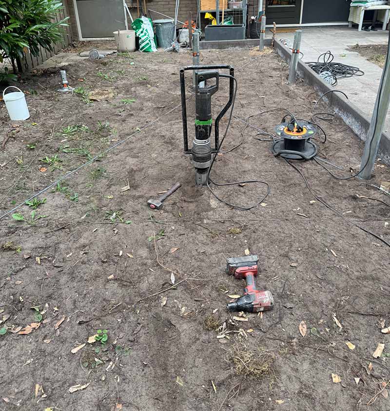 montage-schroeffundering-aanbouw-amsterdam-van-aken Bovenaanzicht van gemarkeerd werkgebied met schroeffunderingen in achtertuin Amsterdam voor aanbouw geschakelde woning